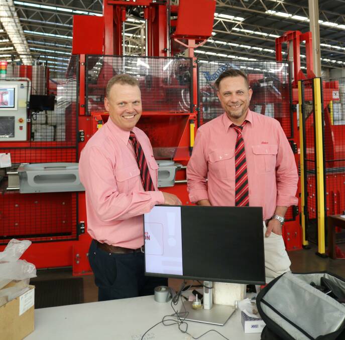  Elders general manager agency, Dave Adamson (left) and Elders wool Rockingham operations manager, Ryan Fletcher in front of the core machine, which is the first of its type in Australia.