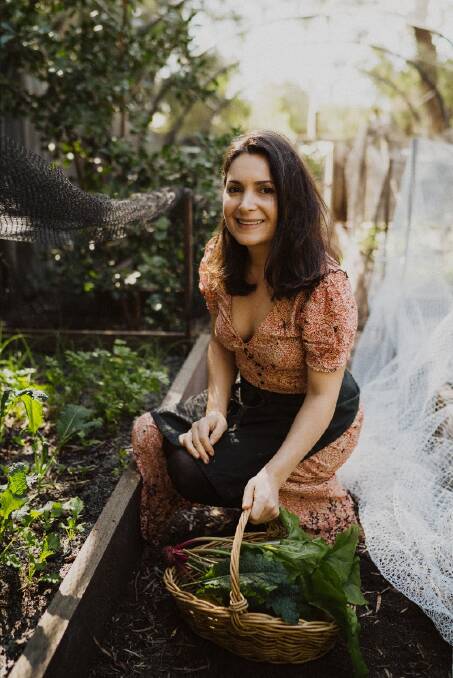 Samira Damirova collects herbs from her garden.
